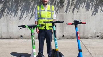 Mayor Phil Glanville, Chair of London Councils' Transport and Environment Committee, stands with e-scooters being used in London's rented e-scooter trial.