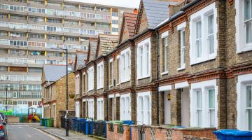 Picture of a London street with terraced houses and a block of flats